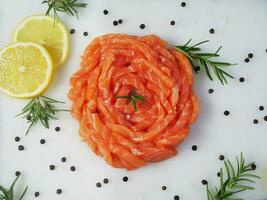 frisch roh Lachs Forelle Filet mit Kochen Zutat Kräuter und Zitrone auf Weiß Teller oben Sicht, Lachs Forelle Scheibe zum Herstellung Sashimi oder Sushi, gesund Reich Omega Ernährung Essen Vorspeise foto