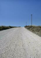 leeren Straße mit ein Leistung Linie und etwas Stangen Nächster zu es im ein ländlich Bereich im Portugal foto