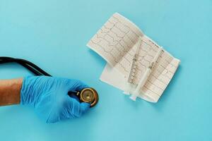 das Arzt Hand hält ein Stethoskop Nächster zu das Kardiogramm und Spritzen foto