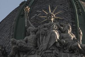 eine Freiheitsstatue sitzt mit einer Fackel in der Hand und zwei Gefährten foto