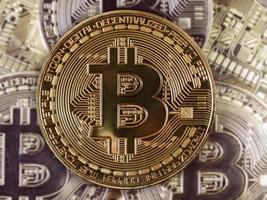 Bitcoin-Symbol unter Haufen goldener Bitcoins foto