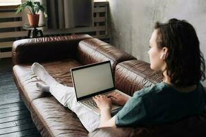 modern Arbeit und Konnektivität, jung Frau nutzen Laptop mit leer Bildschirm beim heim, präsentieren Vielseitigkeit von freiberuflich, Schüler Leben, online Ausbildung, Netz Konferenzen, Video Anrufe, Technologie foto