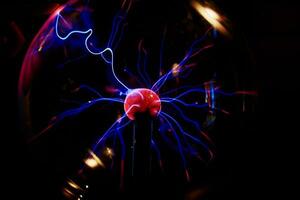 Plasma Ball mit Energie Strahlen auf dunkel Hintergrund foto