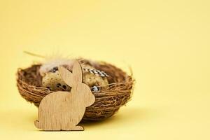 glücklich Ostern Dekoration, hölzern Hase und Eier auf Gelb Hintergrund foto