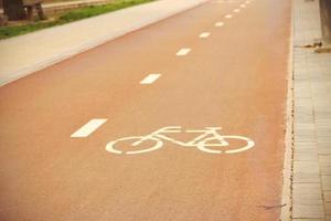roter Fahrradweg in der Innenstadt mit bemaltem Schild foto