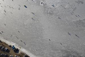 Luftaufnahme der Bucht im Eis mit Fischern beim Winterfischen foto