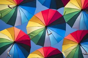 bunter Hintergrund von schönen Regenschirmen gegen den blauen Himmel foto