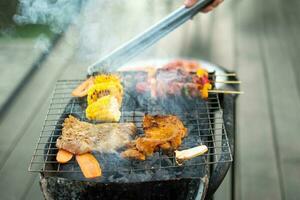 leckeres gegrilltes fleisch mit rauch, grill mit gemüse im freien. grill-, party-, lifestyle- und picknickkonzept foto