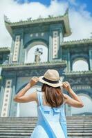 Frau Reisender Besuch beim Linh ung Pagode Tempel, Übersetzung von Chinesisch Charakter. Tourist mit Blau Kleid und Hut Reisen im da nang Stadt. Vietnam und Süd-Ost Asien Reise Konzept foto