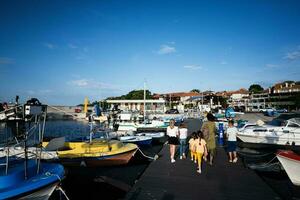 Touristen auf ein Seebrücke im das Hafen von Nessebar, Mutter mit Kinder. foto