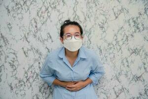 Frau Mann setzt auf ein Gesicht Maske Bauchschmerzen isoliert auf Weiß Hintergrund, Pandemie und Sozial Distanzierung konzept.covid-19 foto