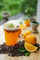 frisch drücken Orange Saft oben mit Kaffee Schuss auf hölzern Tabelle foto