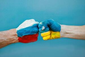 Hände gemalt im Farbe Flaggen von Ukraine und Russland Flagge auf Hände schlagen zu jeder Andere. war.ukraine vs. Russland im Welt Krieg Krise Konzept foto