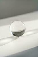 transparent Kristall Ball auf ein Weiß Hintergrund. foto