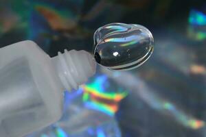 hyaluronic Gel oder Dusche Gel gedrückt aus von ein Flasche auf ein holographisch Hintergrund. foto