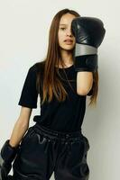schön Mädchen im schwarz Sport Uniform Boxen Handschuhe posieren Fitness Ausbildung foto