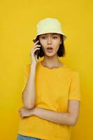 schön Mädchen Gelb T-Shirt und Hut Sommer- Stil mit Telefon Lebensstil unverändert foto