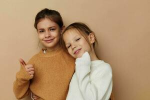 zwei komisch wenig Mädchen im Pullover posieren Kindheit foto