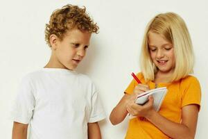 Porträt von süß Kinder Stand Nächster zu Notizblock Bleistift Zeichnung Emotionen Farbe Hintergrund unverändert foto