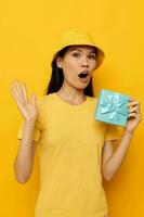 Frau mit asiatisch Aussehen mit ein Geschenk Box im seine Hände Überraschung Emotionen isoliert Hintergrund unverändert foto