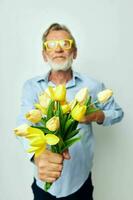 Foto von im Ruhestand alt Mann im ein Blau Hemd mit ein Strauß von Blumen Licht Hintergrund