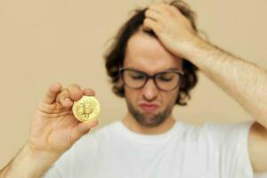 heiter Mann im ein Weiß T-Shirt mit Bitcoin Kryptowährung isoliert Hintergrund foto
