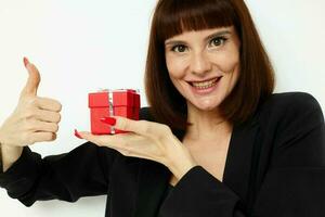 Porträt von ein Frau mit Geschenk klein Box im ein Leder passen schwarz Jacke Lebensstil unverändert foto