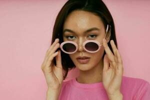 Foto ziemlich Mädchen im ein Rosa T-Shirt Mode Sonnenbrille isoliert Hintergrund