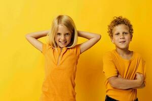 heiter Kinder im Gelb T-Shirts Stehen Seite durch Seite Kindheit Emotionen Gelb Hintergrund foto