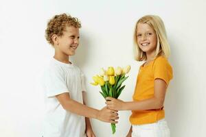 süß Vorschule Kinder mit ein Strauß von Blumen Geschenk Geburtstag Urlaub Kindheit Licht Hintergrund foto