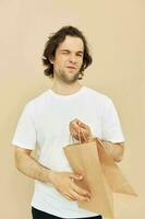 attraktiv Mann Papier Lebensmittelgeschäft Tasche posieren isoliert Hintergrund foto