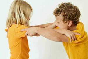 süß stilvoll Kinder im Gelb T-Shirts Stehen Seite durch Seite Kindheit Emotionen Licht Hintergrund unverändert foto