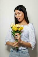 Frau im ein Weiß Hemd Blumen Frühling posieren Licht Hintergrund unverändert foto