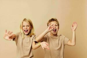 Junge und Mädchen im Beige T-Shirts posieren zum Spaß Kindheit unverändert foto