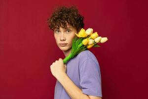 ein jung Mann rot Haar im beiläufig tragen Strauß von Blumen Geschenk rot Hintergrund unverändert foto