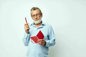 Foto von im Ruhestand alt Mann rot Notizblock Schreiben Licht Hintergrund