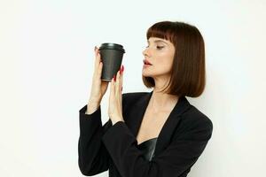 schön Frau im ein schwarz passen ein Becher mit ein trinken Charme isoliert Hintergrund foto