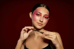 ziemlich Frau Rosa Gesicht bilden posieren attraktiv aussehen Haut Pflege Rosa Hintergrund unverändert foto