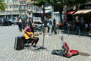 Porto, Portugal Straße Musiker spielen das Gitarre. historisch Stadt, die Architektur von alt Stadt. foto