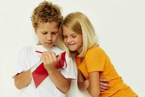 heiter Kinder Spaß im bunt T-Shirts mit ein Notizblock Farbe Hintergrund unverändert foto