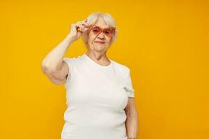 Porträt von ein alt freundlich Frau im beiläufig T-Shirt und Brille Nahansicht Emotionen foto