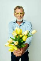 Porträt von glücklich Senior Mann Gelb Strauß von Blumen posieren isoliert Hintergrund foto