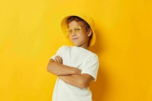 Junge im Gelb Hut mit Brille Kinder Mode Gelb Hintergrund foto