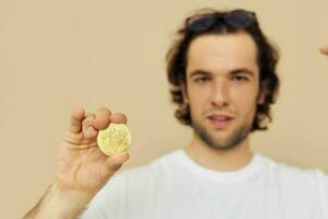 attraktiv Mann im ein Weiß T-Shirt mit Bitcoin Kryptowährung isoliert Hintergrund foto