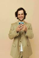 attraktiv Mann mit ein Telefon im Hand Beige passen elegant Stil Lebensstil unverändert foto