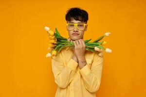 ein jung Mann im Gelb Brille mit ein Strauß von Blumen Urlaub unverändert foto