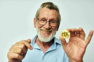 Foto von im Ruhestand alt Mann Finanzen Gold Münzen Bitcoin posieren isoliert Hintergrund