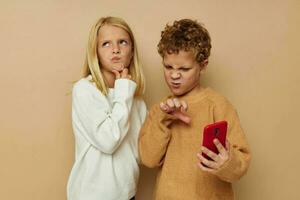 süß stilvoll Kinder Umarmung Unterhaltung Selfie posieren Freundschaft Beige Hintergrund foto