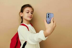 süß Mädchen Schülerin Rucksack Telefon im Hand isoliert Hintergrund foto