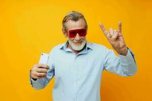 Senior grauhaarig Mann Blau Hemden mit Brille nimmt ein Selfie abgeschnitten Aussicht foto